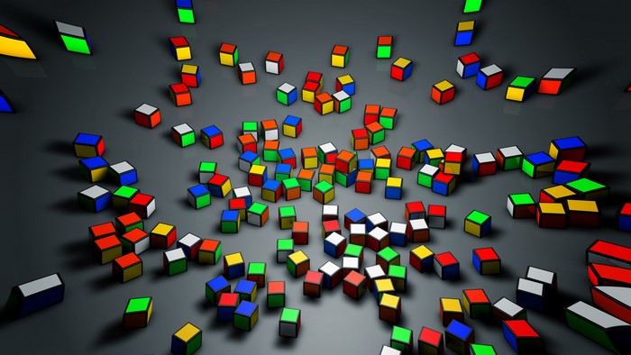 Scattered colorful Rubik's Cubes on a dark surface
