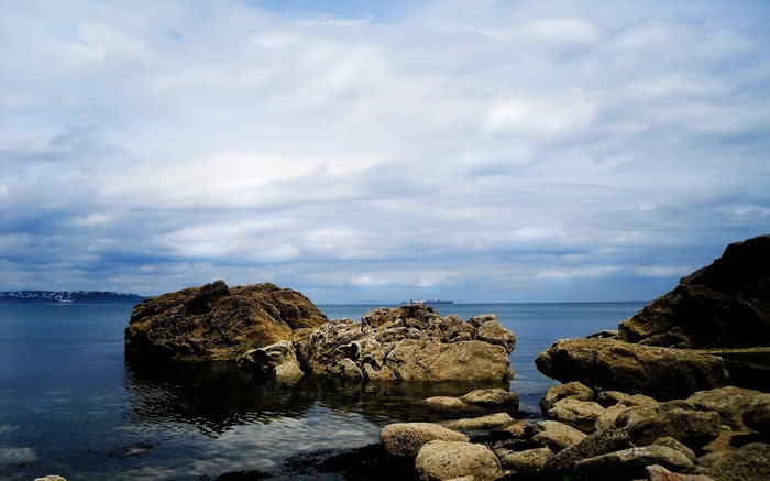 Rocky coastline with a ship on the horizon