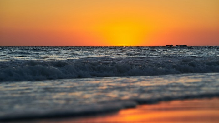 Sunset over the ocean with waves