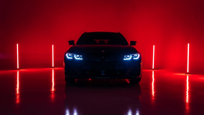 BMW M340i with blue headlights in red light