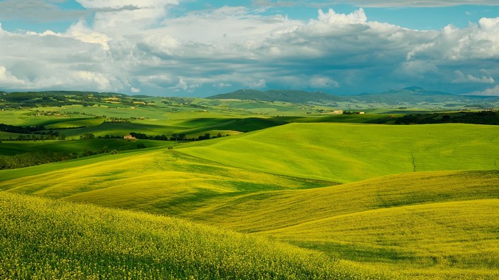 Green rolling hills landscape with clouds