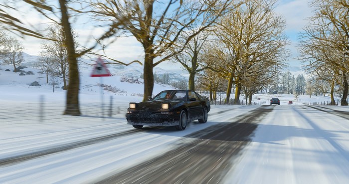 Black Toyota Supra MK3 driving on a snowy road in Forza Horizon 4