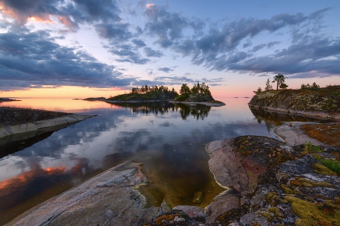 Sunset over islands with reflections in water