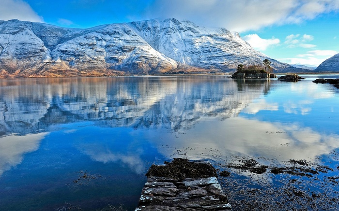 Snow-capped mountains reflected in a calm lake