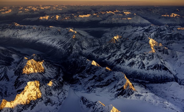 Aerial view of snow-covered mountains in Alaska at sunset