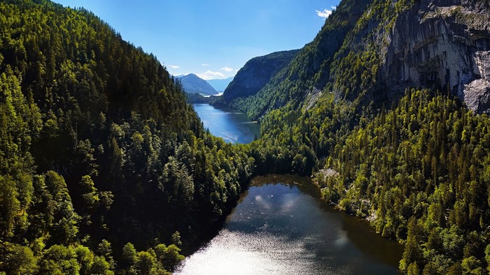 Aerial view of a lake between forested mountains