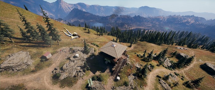Person wingsuiting near a lookout tower in Far Cry 5
