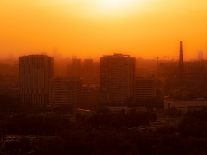 City skyline at sunset with factory chimney