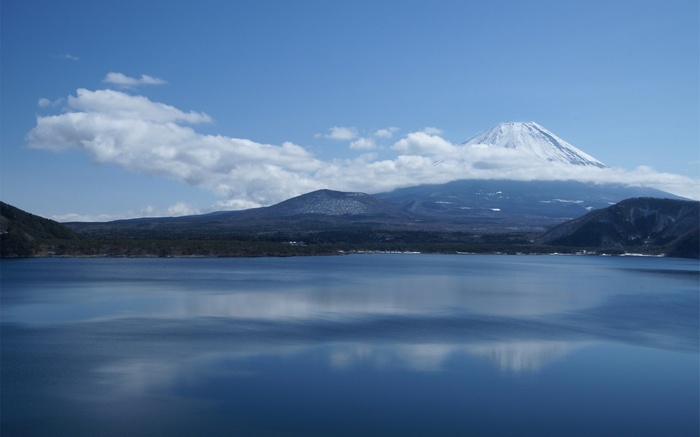 Mount Fuji reflected in a lake under a cloudy sky