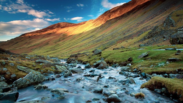Mountain valley with stream and grassy slopes