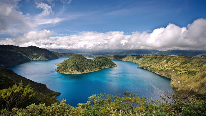 Crater lake with island in Ecuador under a cloudy sky