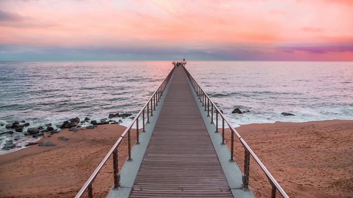Wooden pier over the ocean at sunset