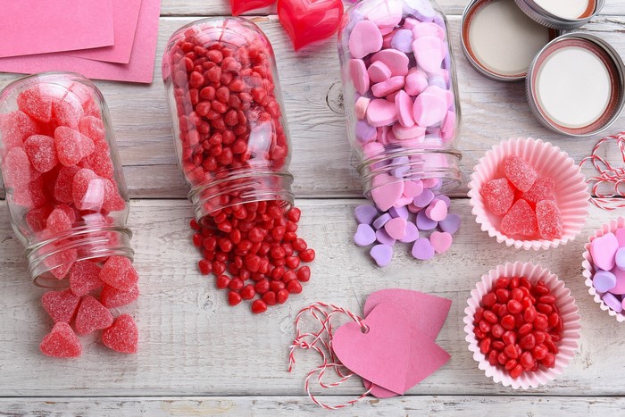 Heart-shaped candies in jars and cups