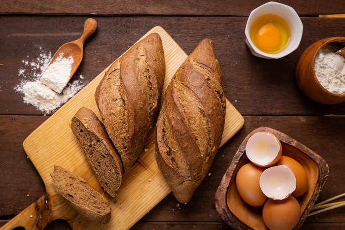 Bread, eggs, and flour on a wooden table
