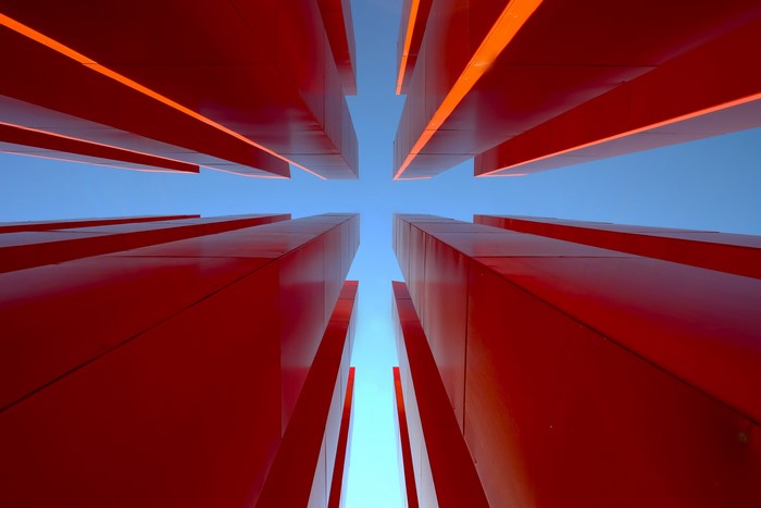 Red structures against a blue sky, worm's eye view