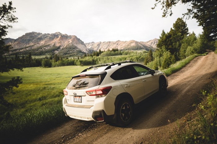 White Subaru Crosstrek on a dirt road in the mountains