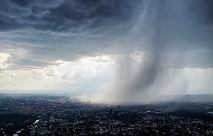Vilnius cityscape under a stormy sky with rain