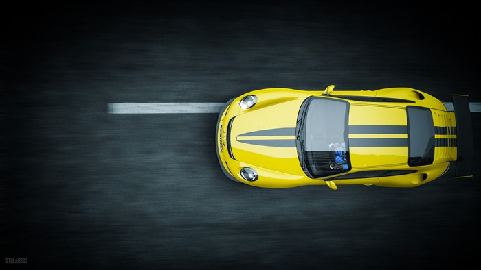 Yellow sports car with racing stripes on a track