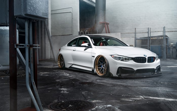 White BMW M4 parked in an industrial area