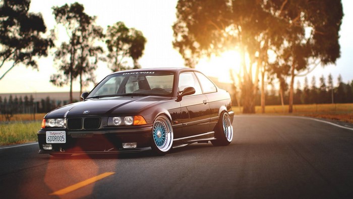 Black BMW E36 Tuner Car with Blue Wheels