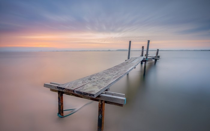Wooden pier on a calm sea at sunset