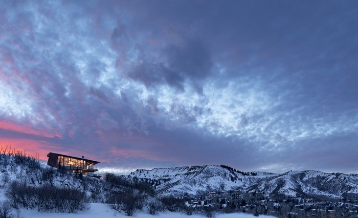 Modern house on a snowy mountain at sunset