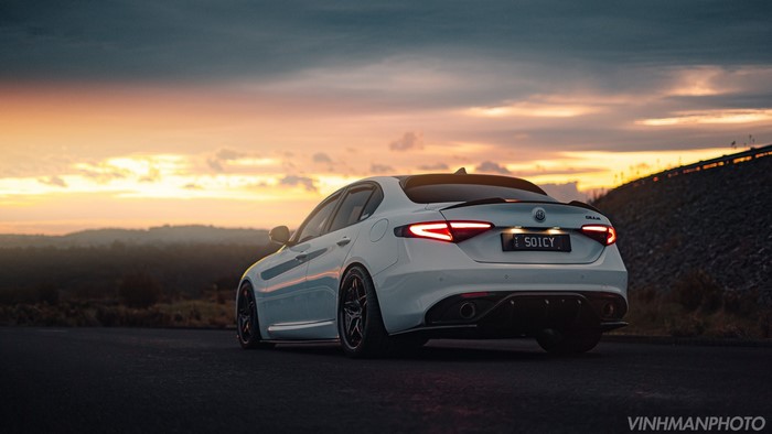 White Alfa Romeo Giulia sports car at sunset