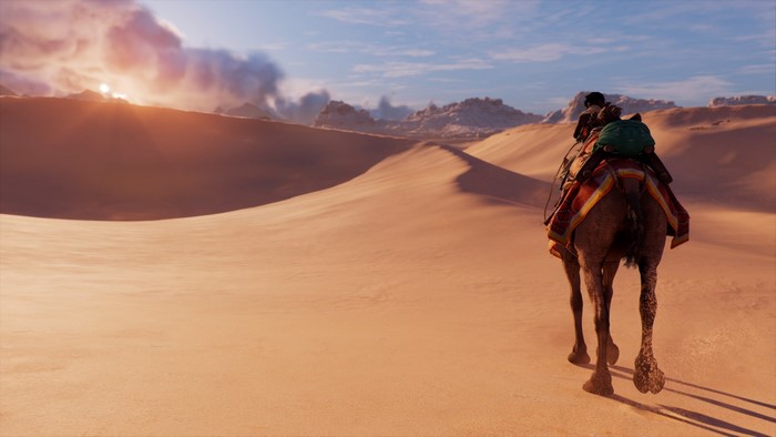 Camel rider in a desert landscape at sunset