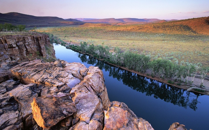 Rocky cliff overlooking a river and savanna