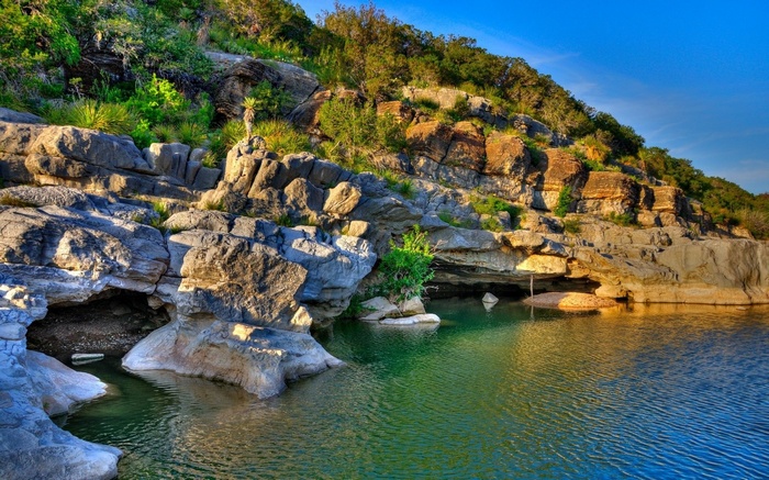 Rocky cliff face with a river and trees