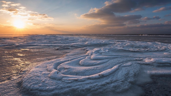 Frozen sea ice formations at sunset