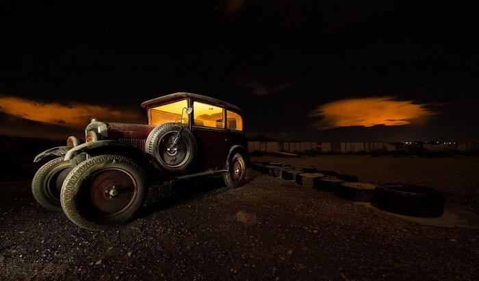 Old car at night with orange clouds