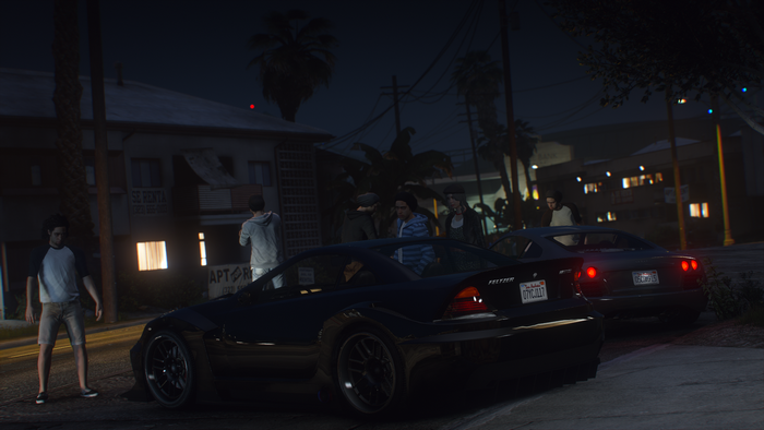 People gathered around cars at night in Grand Theft Auto V