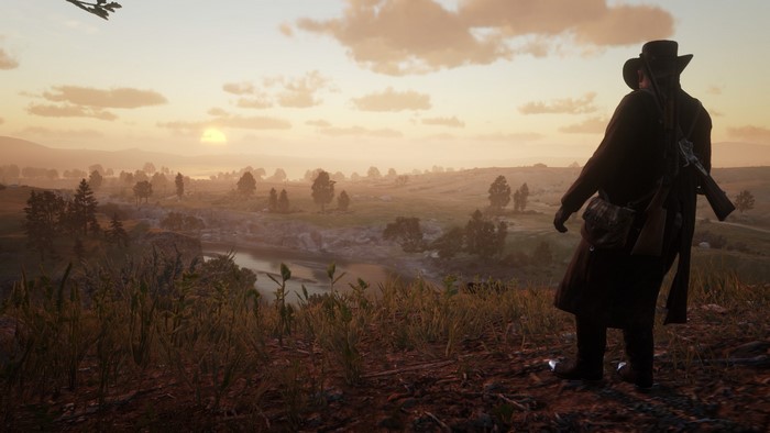Man in hat overlooking a valley at sunset in Red Dead Redemption 2
