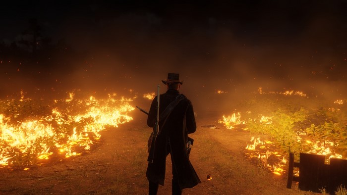 Man in hat in burning field in Red Dead Redemption 2