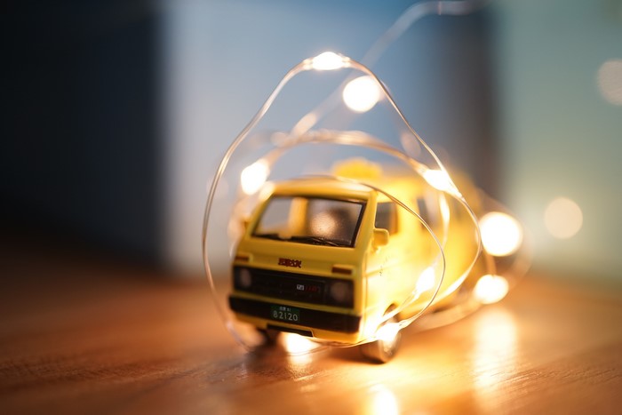 Yellow toy car wrapped in fairy lights