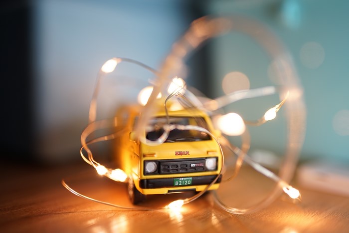 Yellow toy car with fairy lights