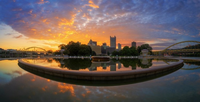 Pittsburgh skyline and bridges at sunset with fountain reflection