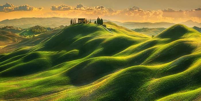 Tuscan hills at sunset with a house