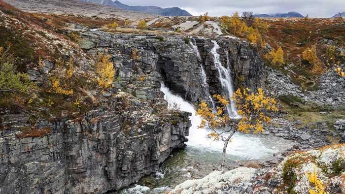 Waterfall in a rocky landscape with autumn foliage