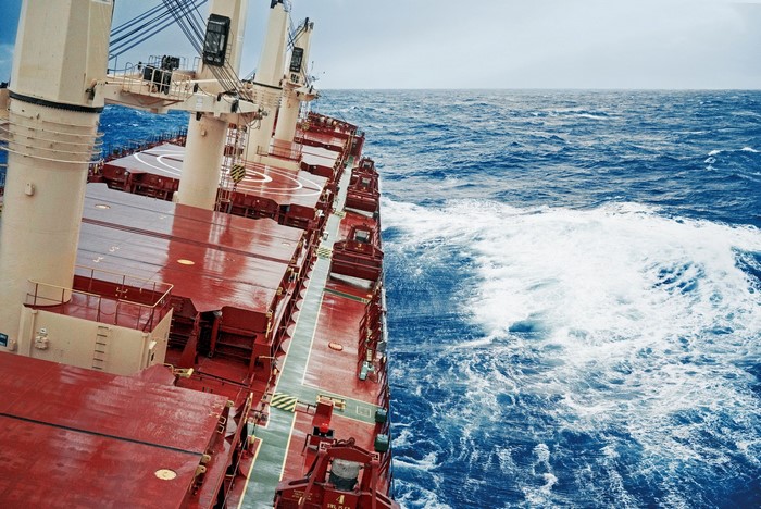 Bulk carrier ship sailing on wavy blue sea