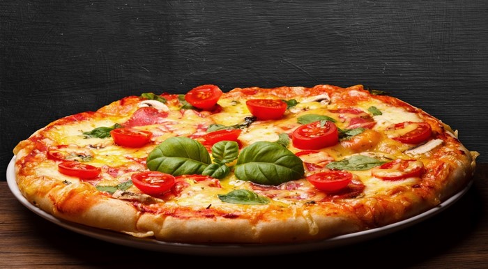 Pizza with tomatoes and basil on a plate
