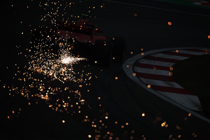 Formula 1 car sparks on dark track
