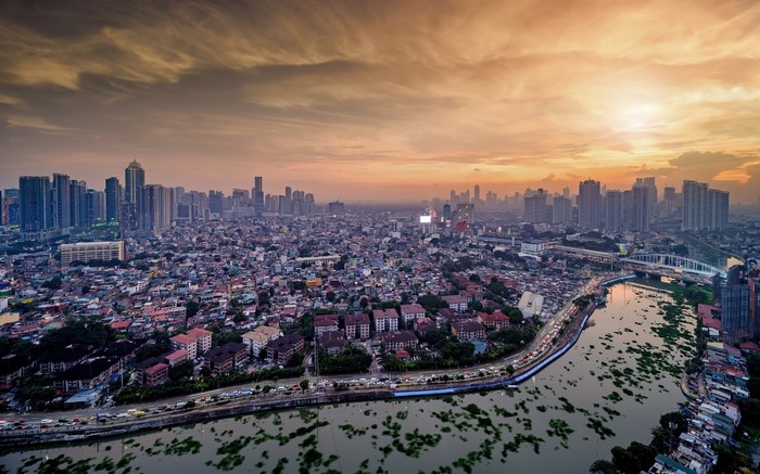 Manila cityscape at sunset with river and buildings