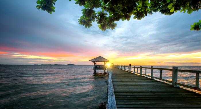 Wooden pier and gazebo on the sea at sunset