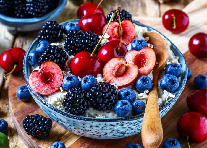 Bowl of oatmeal with berries and cherries
