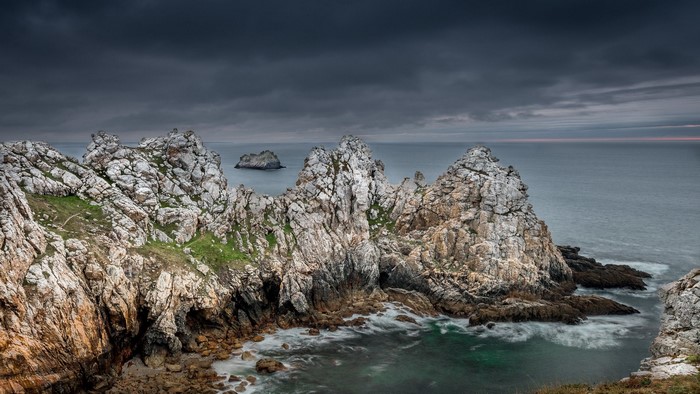 Rocky coast and sea under cloudy sky in France