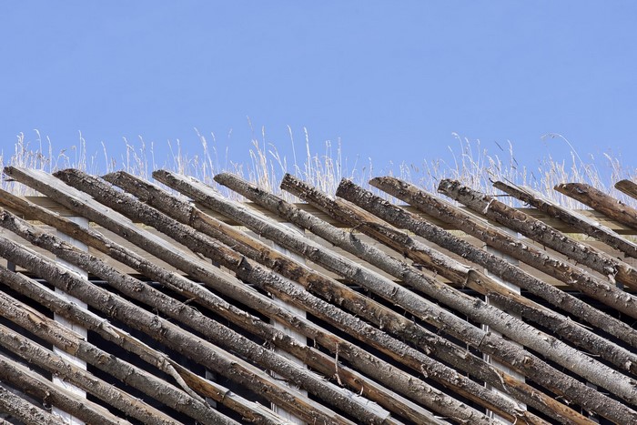 Wooden roof structure against a blue sky