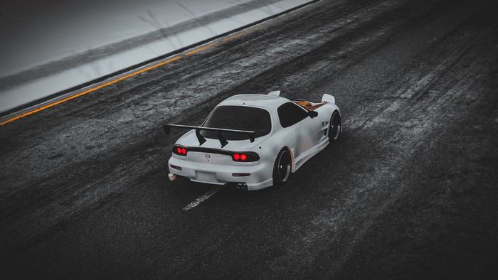 White Mazda RX-7 FD with a large spoiler on a track