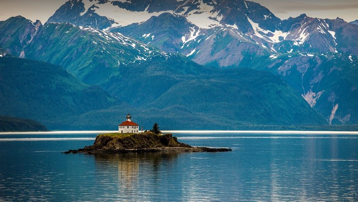 Lighthouse on an island in Alaska with mountains